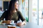 Beautiful Girl Using Her Mobile Phone In Cafe Stock Photo