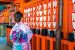 Asian Women Wearing Japanese Traditional Kimono Visiting The Beautiful In Fushimi Inari Shrine In Kyoto, Japan Stock Photo