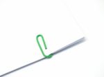 Green Paperclip Attached On White Paper Isolated Stock Photo
