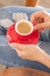 Woman In Torn Jeans Sitting At Coffee Shop Stock Photo