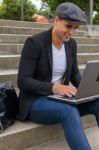 Student Working On His Laptop With An Irish Cap Stock Photo