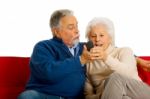 Elderly Couple With Remote Control Stock Photo