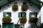 Red Geraniums Hanging From A House In St. Gilgen Stock Photo