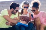 Students Group Looking At A Book In The Street Stock Photo