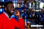 Smiling Young Guy In Bar Looking At Something Stock Photo