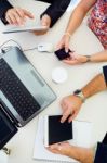 Casual Executives Using Different Electronic Objects At A Meetin Stock Photo