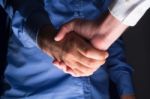 Handshake Handshaking In Dark With Low Light Stock Photo