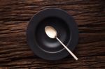 Black Empty Bowl Spoon On Wooden Table Background Stock Photo