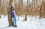 Young Beautiful Woman Walking Under A Snowfall Stock Photo