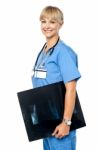 Nurse Holding X-ray Sheet To Be Passed Up To A Senior Doctor Stock Photo