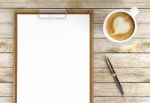 Cappuccino Coffee Cup With Blank Papers On Clipboard And Ballpoint Pen On Wooden Background, Coffee And Business Background Stock Photo