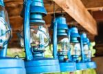 Perspective View Of Storm Lanterns Hanged On Wooden Counterpoise Stock Photo