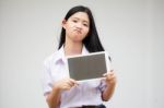 Portrait Of Thai High School Student Uniform Beautiful Girl Using Her Tablet Stock Photo