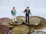 Miniature Businessman Stand On Euro Coins And Book Bank. Busines Stock Photo