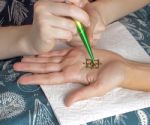 The Process Of Applying Mehendi On A Woman's Hand Stock Photo