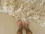 The Traveler Stand On The Sand Beach With Sea Wave Stock Photo