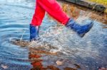 Girl Standing In A Puddle Of Water Splashes Stock Photo