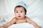 Sweet Newborn Baby In White Hat Lies On Bed Stock Photo