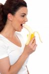 Young Girl Eating Banana Stock Photo