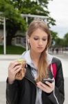 Teenager Eating Cake Looking In Phone Stock Photo