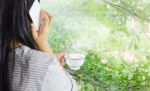 Women Hold Cup Of Coffee And Talking On Mobile Or Smartphone Stock Photo