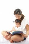 Mother Is Reading A Book For Her Baby Stock Photo