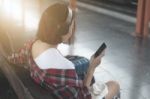 Traveler Girl Using Tablet And Headset With A Luggage Sitting An Stock Photo