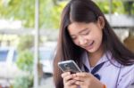 Portrait Of Thai Student Teen Beautiful Girl Using Her Phone And Smile Stock Photo