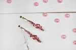 Golden Hairpins With Pink Gemstone And Pink Pearls On White Wood Stock Photo