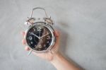 Woman Hand On Alarm Clock Stock Photo