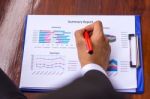 A Business Man Is Using A Pen To Write On The Paper Reported Stock Photo