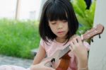 Asian Girl Playing The Ukulele Stock Photo