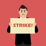 Businessman Holding Strike Banner Stock Photo