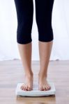 Young Healthy Girl On Weight Scales At Home Stock Photo