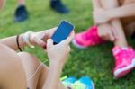 Running Girls Having Fun In The Park With Mobile Phone Stock Photo