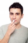 Young Man Applying Lip Balm Stock Photo