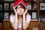 Portrait Of Thai Adult Student University Uniform Beautiful Girl Reading Red Book Stock Photo