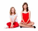 Teenage Sisters Sitting On Floor Stock Photo