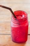 Iced Drink In Red Glass On Wooden Table Stock Photo