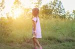 Adorable Little Girl Laughing In A Meadow - Happy Girl At Sunset Stock Photo