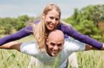 Young Man Giving Shoulder Ride To Her Girlfriend Stock Photo