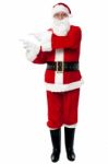 Man In Santa Costume Indicating At Copy Space Area Stock Photo