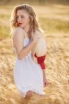 Lonely Beautiful Young Blonde Girl In White Dress With Straw Hat Stock Photo