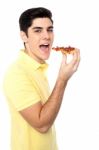 Young Guy With A Slice Of Pizza In Hand Stock Photo