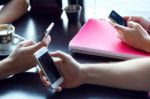 Group Of Friends Using Mobile Phone In Cafe Stock Photo