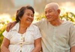 Happy Senior Couple Sitting Outdoors Stock Photo