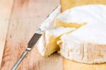 Camembert Cheese With Cut Wedge And Vintage Knife On Wooden Tabl Stock Photo