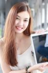 Portrait Of Thai Adult Beautiful Girl Using Her Tablet And Smile In University Stock Photo