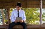 Young Students Use Tablets On Bamboo Houses In The Countryside Stock Photo