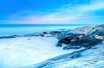 The View Of The Sand Beach And Sea Wave With Rock And Reef On Morning With Sunrise Stock Photo